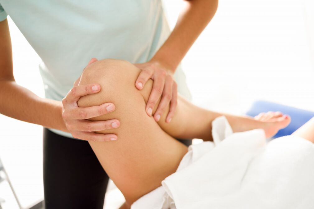 The specialist makes the therapeutic massage with arthrosis of the knee